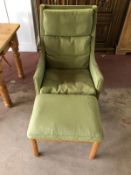 A mid 20th century green wing armchair with footstool