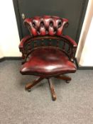 A good quality burgundy leather and mahogany revolving desk chair