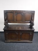 A carved oak storage monk's bench