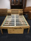 A pine 4'6 bed frame with storage drawers and a pair of bed stands