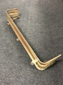 An early 20th century brass fender on paw feet