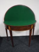 A George III inlaid mahogany demi lune games table