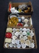 Three boxes of commemorative china and tins, cutlery, cat ornaments,
