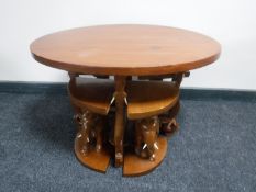 An oval mahogany coffee table on elephant leg support fitted four tables beneath