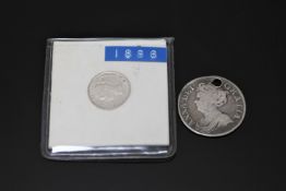 A Queen Anne Shilling 1711, pierced at 12 o' clock. Together with a Victorian three pence 1886.