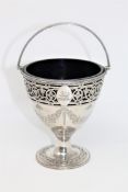 An ornate George III silver sugar basket, with family crest, blue glass liner, maker W P,