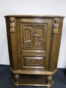 A continental carved oak corner cabinet