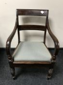 An antique mahogany scroll arm armchair