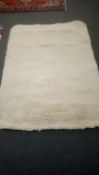 A contemporary hand made shaggy pile wool carpet in cream, 220 cm x 163 cm (rrp £513.