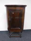 An antique stained pine corner cabinet