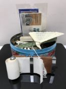 A tin containing costume jewellery, vintage corkscrew, hand fan,