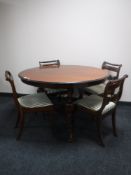An antique mahogany dining table and four chairs in striped fabric
