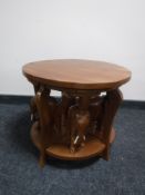 A circular mahogany coffee table fitted four tables beneath with elephant pedestals