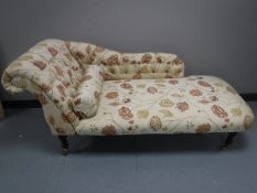 A button back chaise lounge in floral fabric