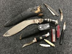 A Kukri knife in sheath together with a hunting knife and a small collection of penknives