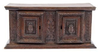 An early 18th Century Continental carved oak table cabinet:, with a moulded cornice,