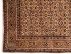 A Sivas carpet:, the beige field with an all over geometric palmette, medallion and leaf design,
