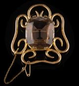 A smoky quartz single-stone brooch: the central,
