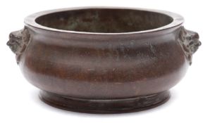 A Chinese bronze censer: of compressed circular form with buddhist lion mask handles,