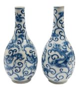 A pair of Chinese blue and white bottle vases: each painted with opposing dragons amongst lingzhi