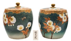 A pair of Satsuma earthenware jars and covers: of barrel shaped form decorated with flowering