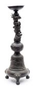A Japanese bronze tripod stand: of baluster form, the neck applied with a sinuous scaly dragon,