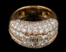 A diamond mounted domed cluster ring: the three principal, baguette-cut diamonds approximately 0.