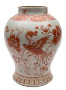 A Chinese porcelain baluster jar: decorated in iron red with a phoenix and tree peonies in a fenced
