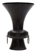 A Chinese bronze vase: of trumpet shaped outline, the knopped stem with dragon mask ring handles,