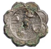 A Chinese silvered bronze mirror: of foliate eight lobed form, cast with birds, flowers and foliage,
