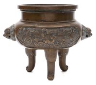 A Chinese bronze tripod censer: with buddhist lion mask handles and cast with panels of a deer,