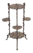 A wrought iron tiered occasional table:, of pierced leaf design,