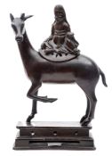A 19th century Chinese bronze figure of Lu-Hsing: seated on the back of a stag,