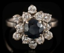 A sapphire and diamond mounted round cluster ring: with central round dark blue sapphire 6.
