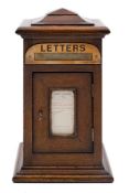 A late Victorian/Edwardian oak domestic letter box: with stepped domed top,