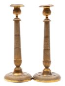 A pair of 19th century French brass candlesticks: with urn-shaped nozzles on spiral decorated
