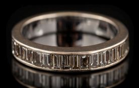 A baguette-cut diamond mounted half-eternity ring: the band channel-set with single row of