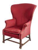 A George III carved mahogany wing frame armchair:, with a curved upholstered stuff over back,