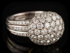 An 18ct white gold and diamond mounted oval bombe cluster ring: the raised oval cluster between