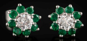 A pair of emerald and diamond mounted circular earrings: each with a central round,