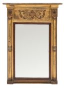 A Regency giltwood and gesso pier mirror:, the moulded cornice of recessed broken outline,