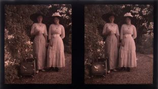 An early 20th century autochrome photograph stereoscope plate of two ladies in a garden:,