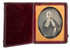 A mid 19th century English daguerreotype of a woman wearing a lace bonnet and collar,