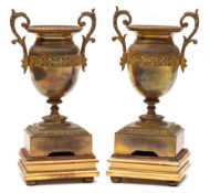 A pair of 19th century gilt metal twin-handled urns: of classical design with scroll handles to the