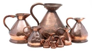 A large 19th century copper measuring jug: together with eight near matching graduated measuring