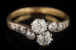 An early 20th century gold and diamond crossover ring: with two principal round old,