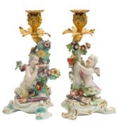 A pair of Derby gilt-metal mounted cupid candlesticks: one holding a heart, the other a bow,