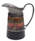 A Moorcroft pottery pewter mounted jug: of tapering cylindrical form with hammered pewter mounts,