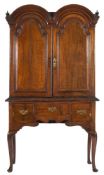An early 18th Century oak double domed cabinet on an associated later 18th Century stand:,