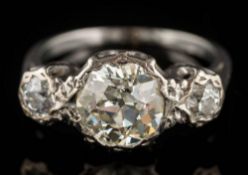 An illusion-set diamond three-stone ring: the principal round old-cut diamond approximately 8mm